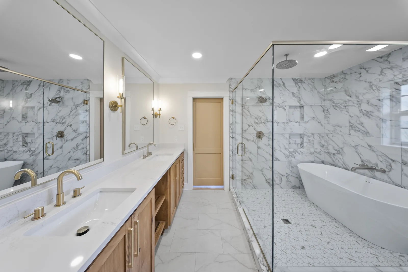 Completed bathroom with glass shower, warm wood cabinetry and brass fixtures