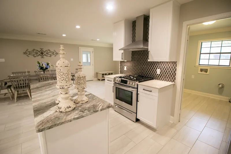 White kitchen with granite island and tile backsplash