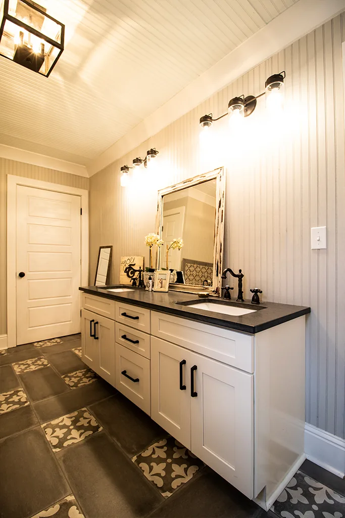 Finished powder room with a dark vanity and patterned tile floor