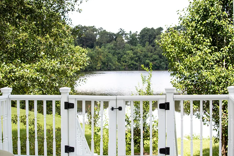 Water view beyond white gazebo railing