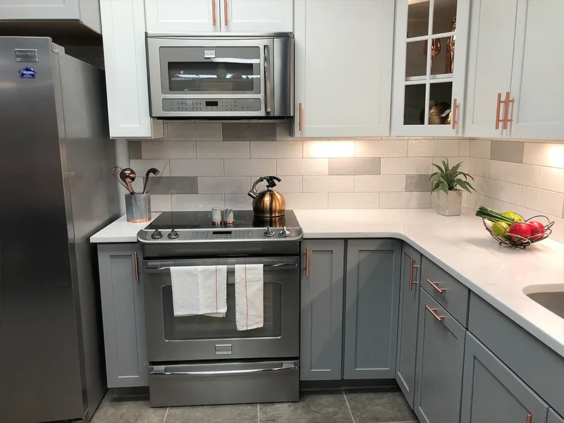 Blue-gray U-shaped kitchen with copper hardware